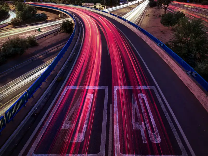 Autovía de entrada a Madrid al atardecer, con estelas de luz de los coches